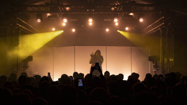 Shygirl sul palco con luci soffuse e il pubblico che la accerchia